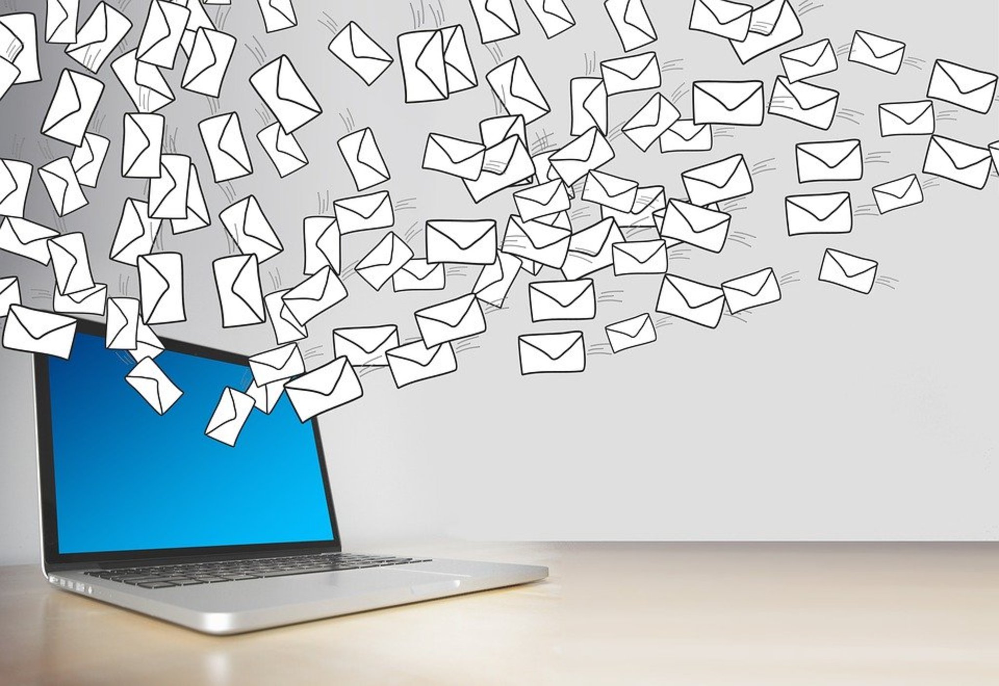 computer with cartoon envelopes flying out of it